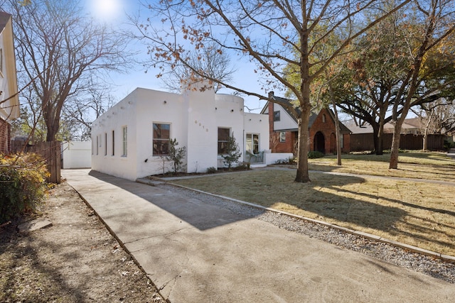 adobe home featuring a front lawn