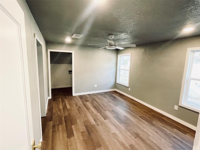 interior space featuring hardwood / wood-style flooring, ceiling fan, and a textured ceiling