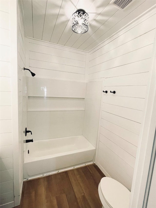 bathroom with hardwood / wood-style flooring, shower / bathtub combination, and toilet