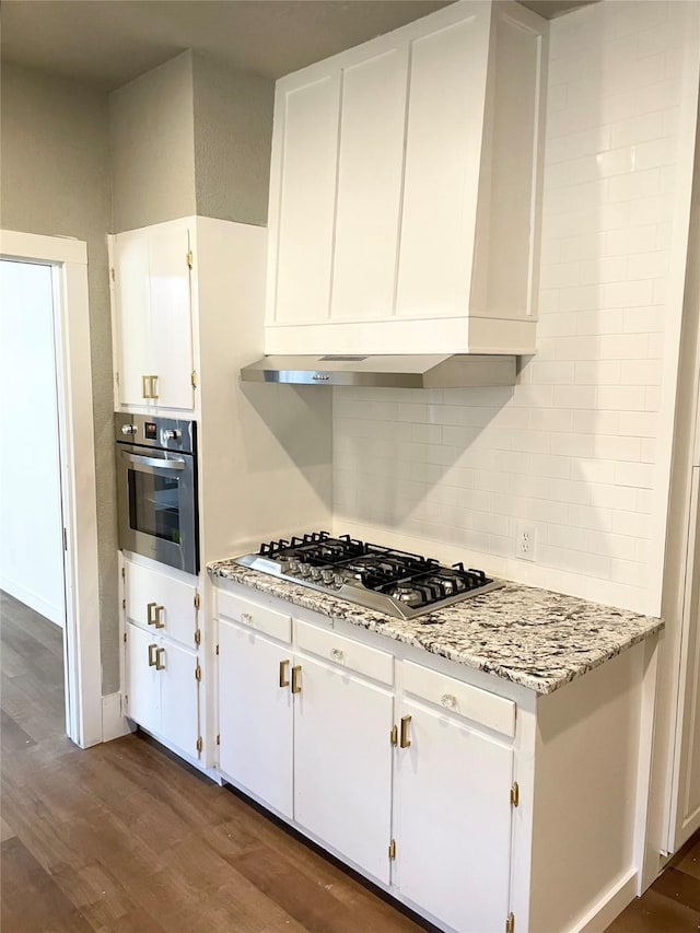 kitchen featuring white cabinetry, light stone counters, dark wood-type flooring, and stainless steel appliances