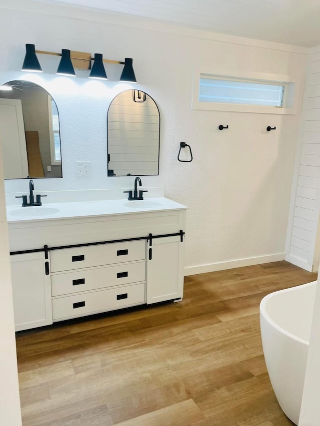 bathroom featuring vanity, a tub to relax in, and hardwood / wood-style flooring