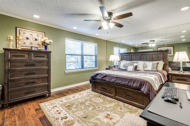 bedroom featuring ceiling fan, ornamental molding, dark hardwood / wood-style floors, and a textured ceiling