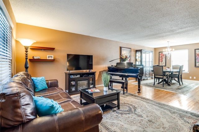 living room with an inviting chandelier, hardwood / wood-style flooring, and a textured ceiling