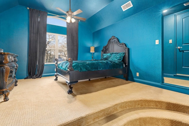 carpeted bedroom with ceiling fan and vaulted ceiling