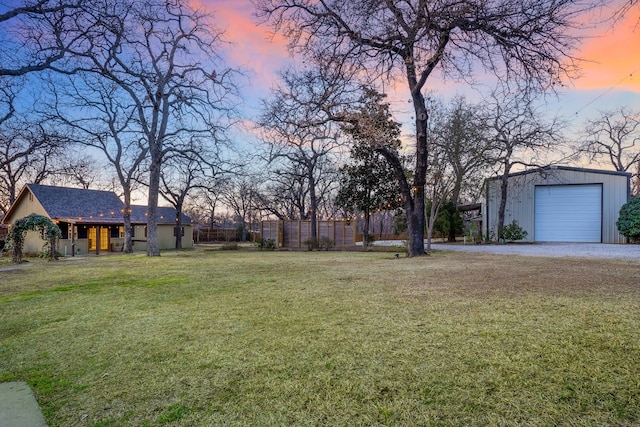 yard at dusk with an outbuilding and a garage