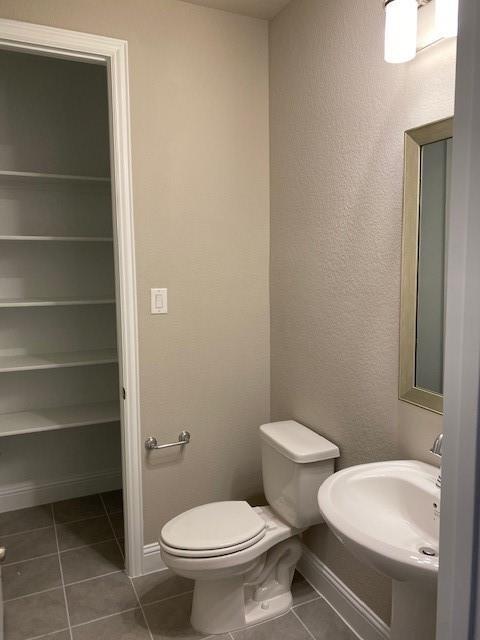 bathroom featuring sink, toilet, and tile patterned flooring