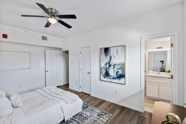 bedroom featuring sink, ensuite bath, dark hardwood / wood-style floors, and ceiling fan