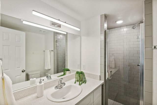 bathroom with vanity, walk in shower, and toilet