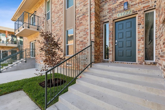 entrance to property featuring brick siding