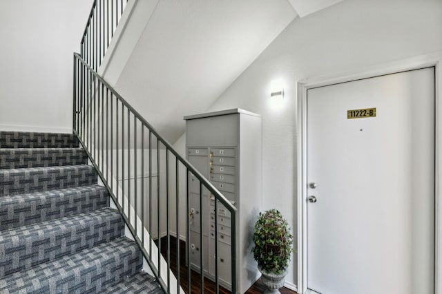 stairs with lofted ceiling and a mail area