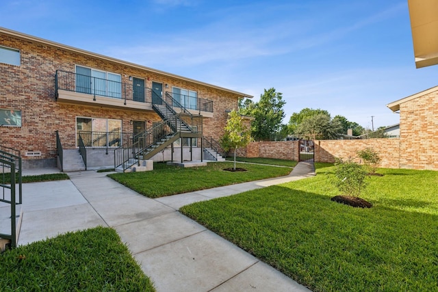 exterior space with a balcony and a front yard