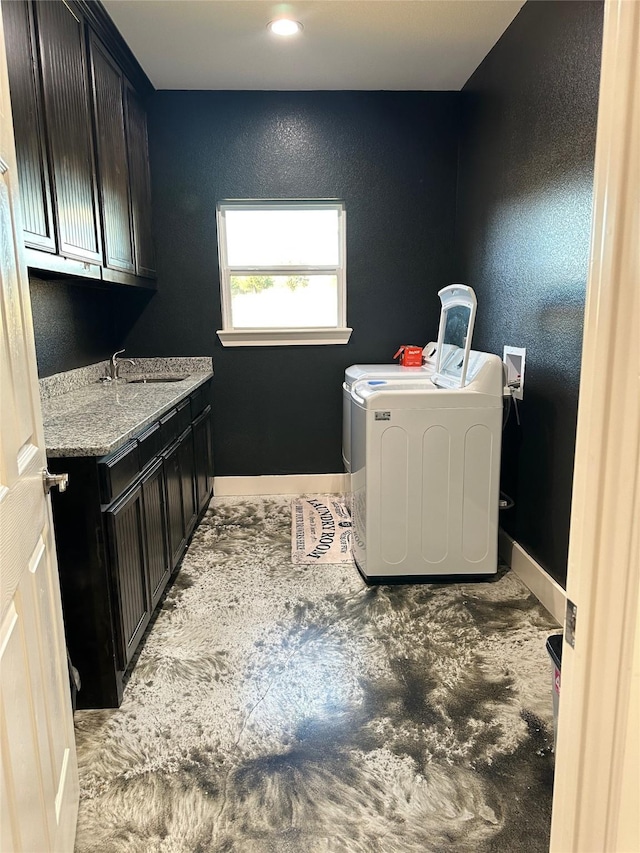 clothes washing area with washer and dryer, sink, and cabinets