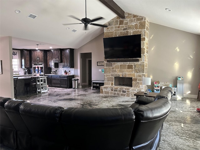 living room with ceiling fan, a stone fireplace, and lofted ceiling with beams