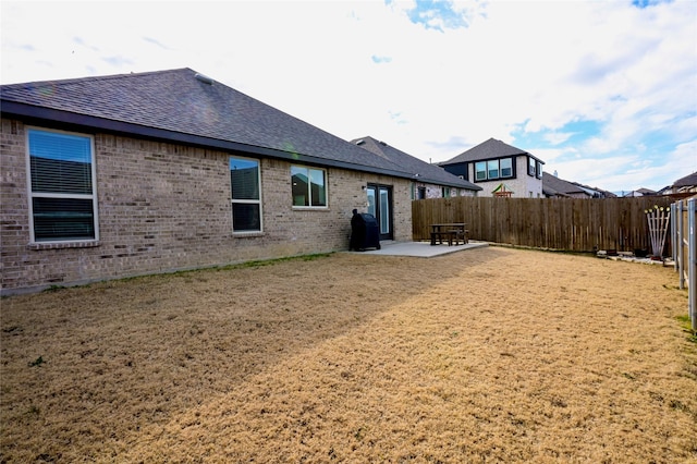 rear view of property with a yard and a patio area