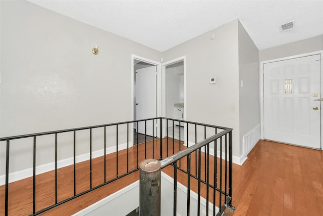 hallway with hardwood / wood-style flooring