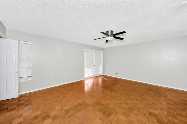 empty room featuring parquet floors, ceiling fan, and a textured ceiling