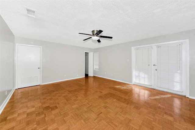 unfurnished room featuring a textured ceiling, parquet flooring, and ceiling fan