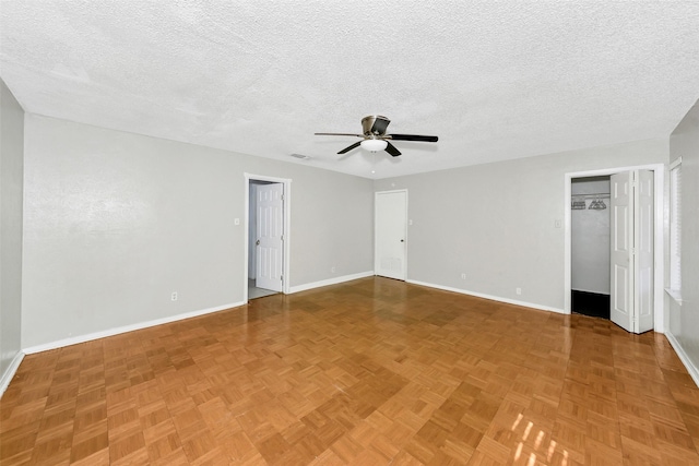 spare room with ceiling fan, parquet flooring, and a textured ceiling