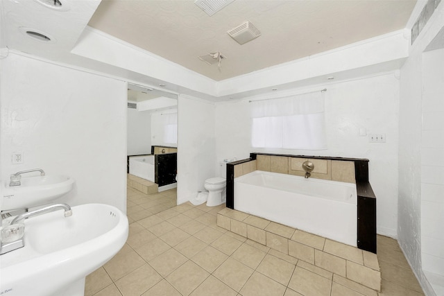 bathroom featuring tile patterned floors, toilet, sink, and a bathtub