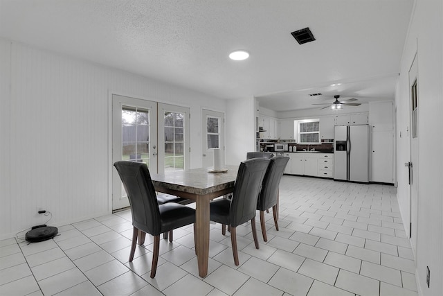 dining space featuring french doors, ceiling fan, a textured ceiling, and light tile patterned floors