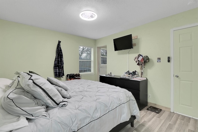 bedroom featuring a textured ceiling and light wood-type flooring