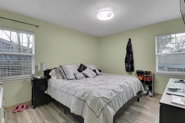 bedroom featuring light hardwood / wood-style flooring and a textured ceiling