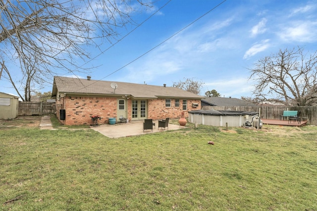 321 Bowles Ct, Kennedale, TX 76060 - rear view of property featuring a fenced backyard, a yard, a wooden deck, french doors, and brick siding