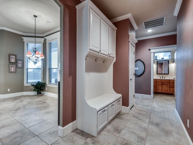 mudroom with an inviting chandelier, light tile patterned floors, and ornamental molding