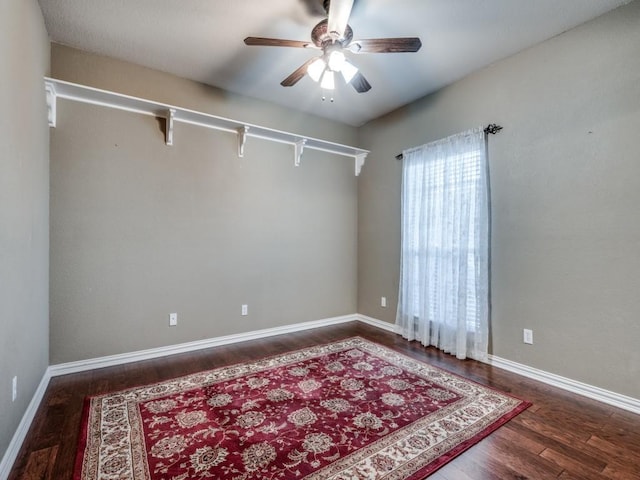 unfurnished room featuring dark wood-type flooring and ceiling fan