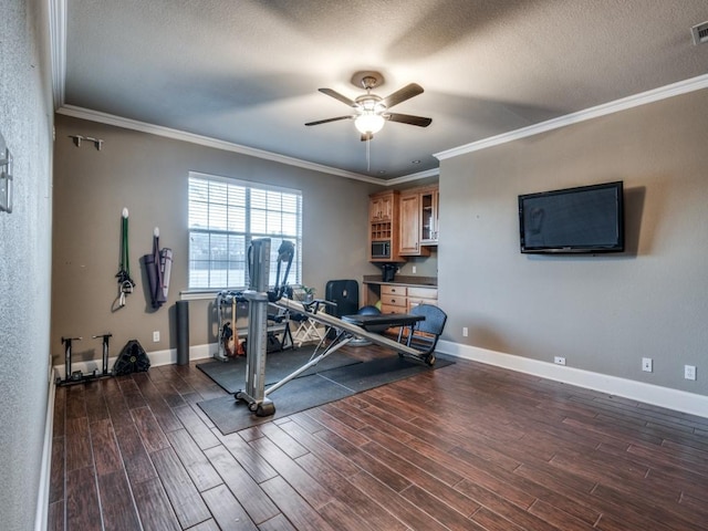 exercise room with crown molding, dark wood-type flooring, and ceiling fan