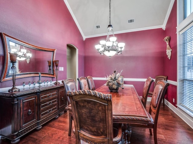 dining space featuring crown molding, vaulted ceiling, dark wood-type flooring, and a notable chandelier