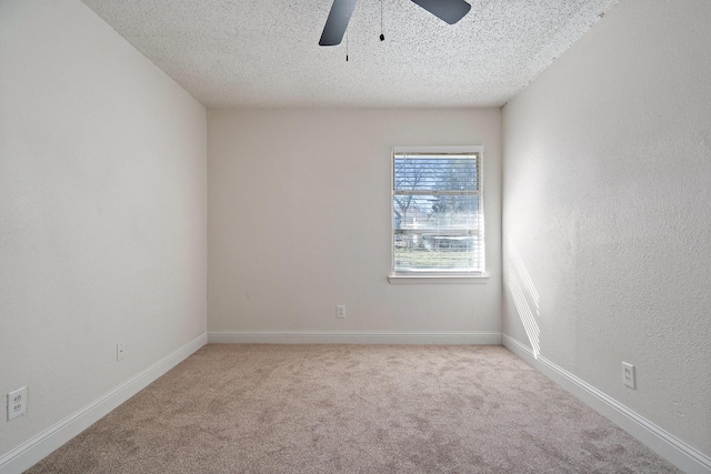 spare room with ceiling fan, light colored carpet, and a textured ceiling