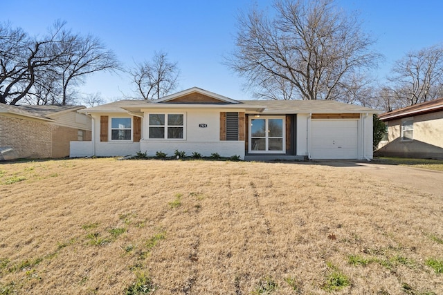 single story home featuring concrete driveway, brick siding, an attached garage, and a front yard