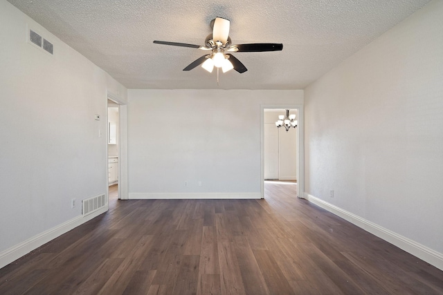 spare room featuring dark wood-style floors, a textured ceiling, visible vents, and baseboards