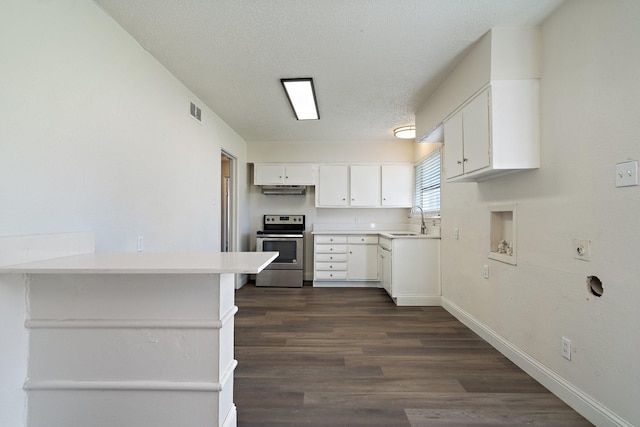 kitchen featuring sink, white cabinetry, stainless steel electric range oven, a textured ceiling, and kitchen peninsula