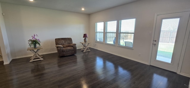 sitting room with plenty of natural light and dark hardwood / wood-style floors