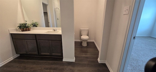 bathroom featuring wood-type flooring, vanity, and toilet