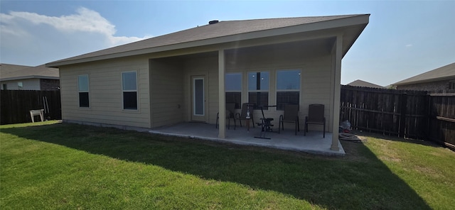 back of house featuring a lawn and a patio area