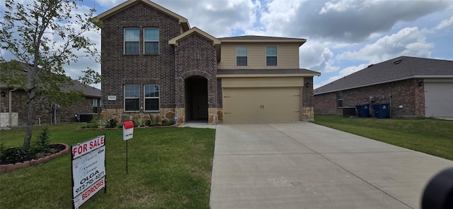 view of property with a garage and a front lawn