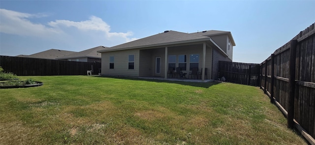 back of house featuring a yard and a patio area