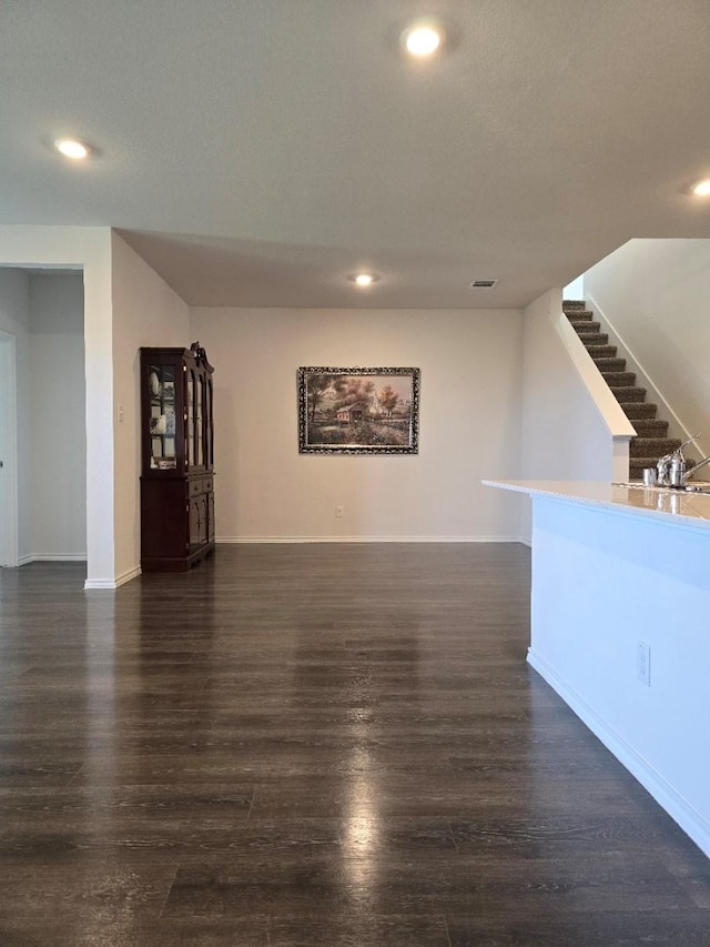 unfurnished living room with dark wood-type flooring