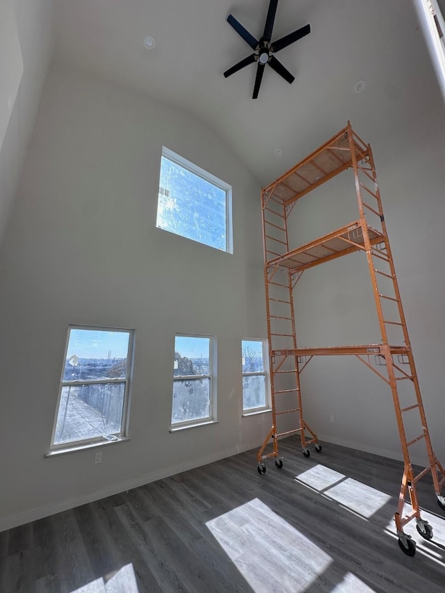 interior space with dark wood-type flooring, ceiling fan, and vaulted ceiling