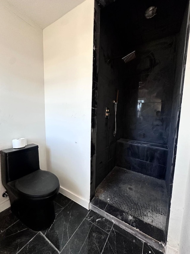 bathroom featuring toilet and a tile shower