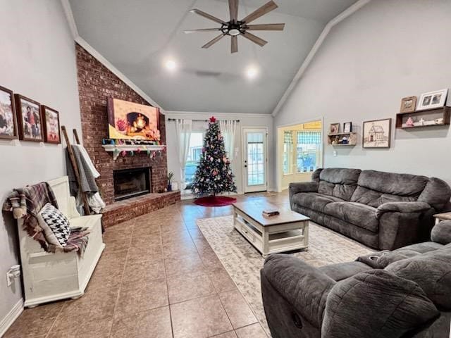 tiled living room featuring ceiling fan, a brick fireplace, ornamental molding, and high vaulted ceiling