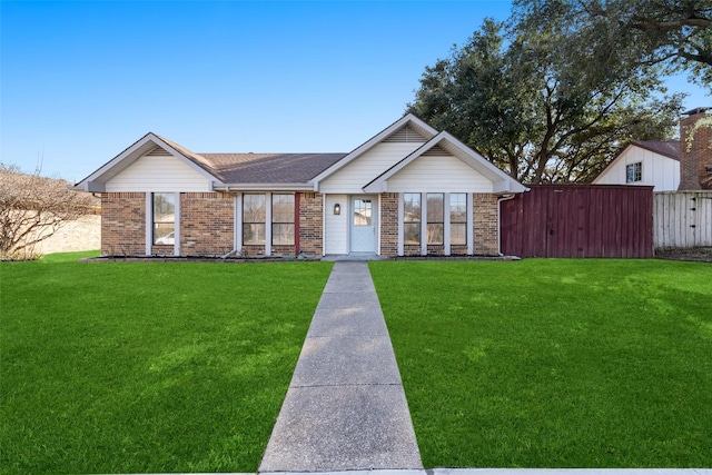 single story home featuring brick siding, fence, and a front lawn