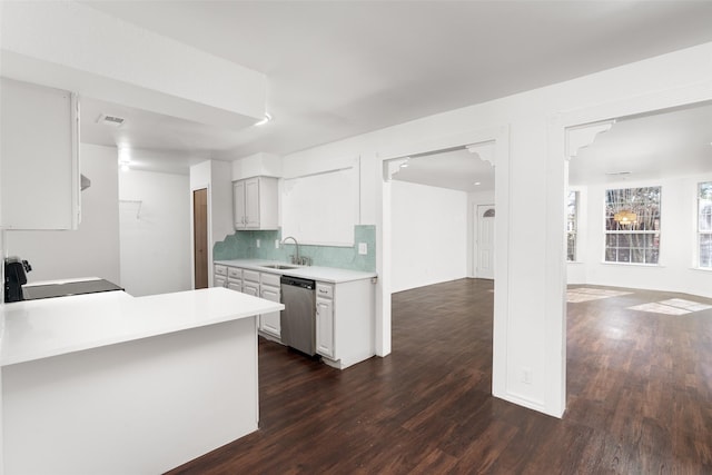 kitchen featuring sink, tasteful backsplash, white cabinetry, dishwasher, and stove