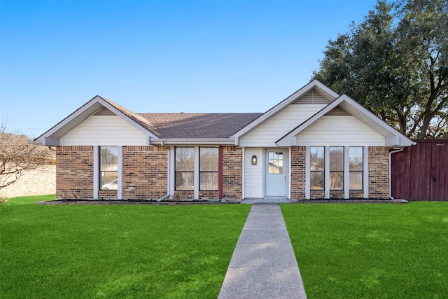 ranch-style home featuring a shingled roof, brick siding, fence, and a front lawn