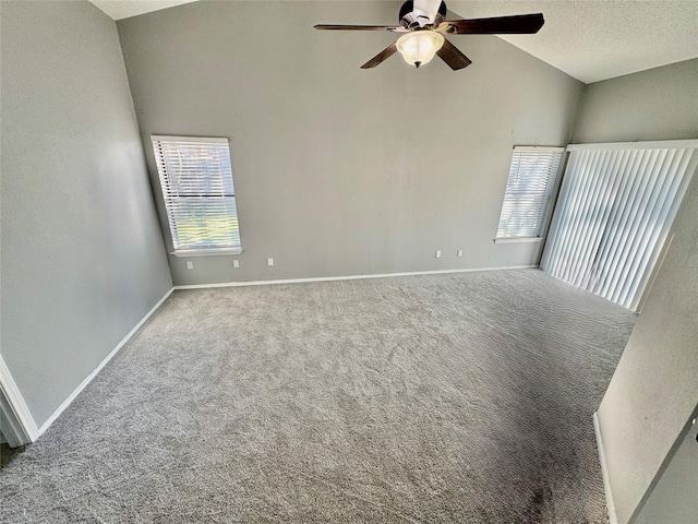 spare room featuring ceiling fan, vaulted ceiling, a textured ceiling, and carpet flooring