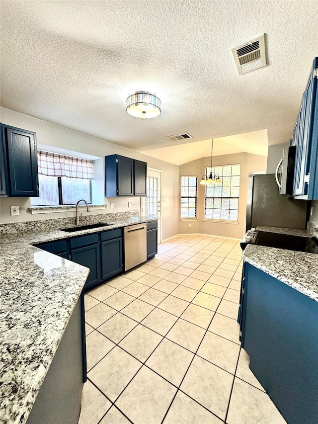 kitchen featuring sink, light tile patterned floors, appliances with stainless steel finishes, hanging light fixtures, and blue cabinets