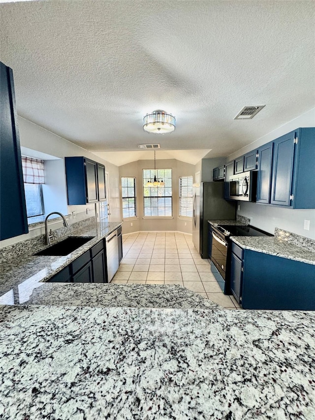 kitchen featuring blue cabinets, sink, light tile patterned floors, and appliances with stainless steel finishes